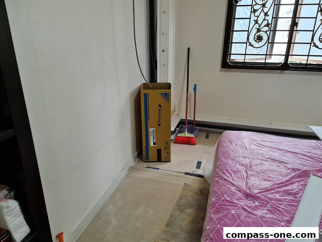 A Daikin air conditioner box stands next to a broom and dustpan near a window.