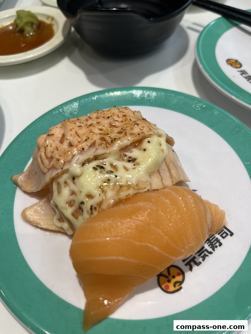 Close-up of two salmon sushi pieces on a plate with a green rim.