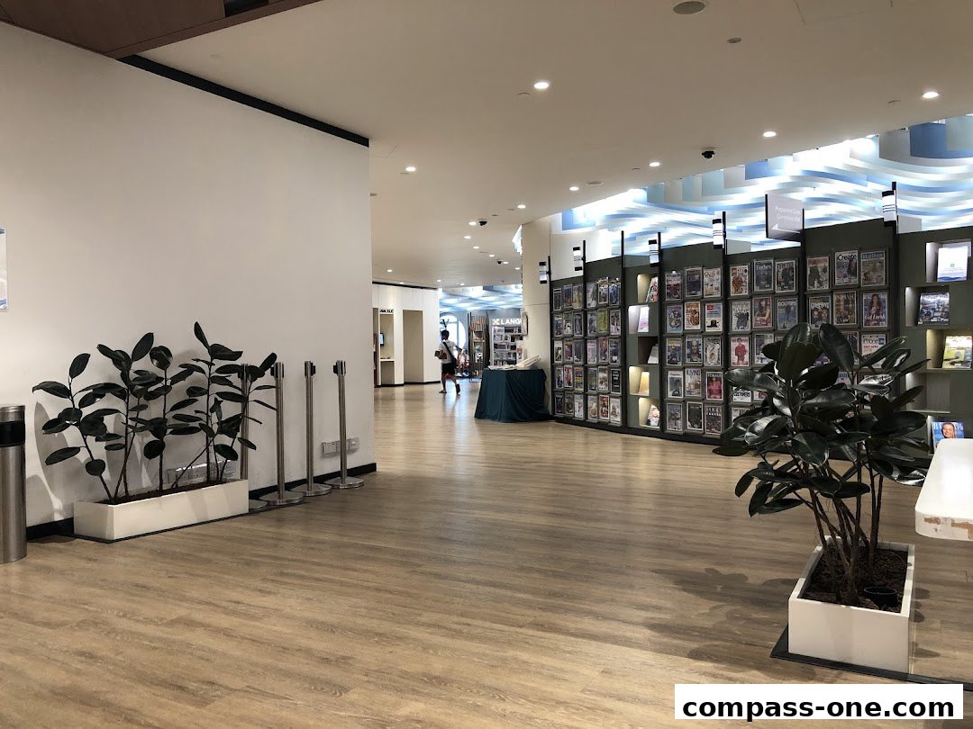 Interior view of a library with shelves of magazines and plants.