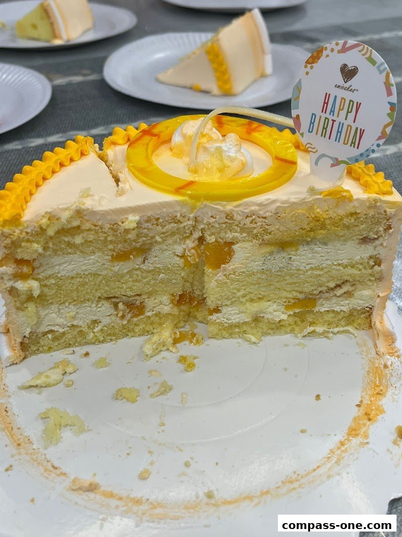 A sliced cake with 'Happy Birthday' topper, served on a white plate with other cake slices.