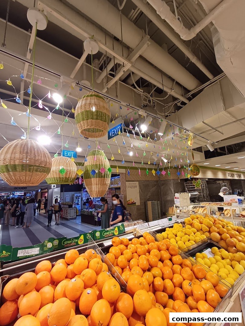 A vibrant display of fresh oranges and lemons at a grocery store, with decorative lighting overhead.