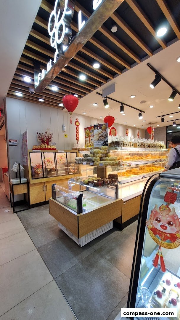 Interior view of a bakery with display cases filled with pastries and cakes.
