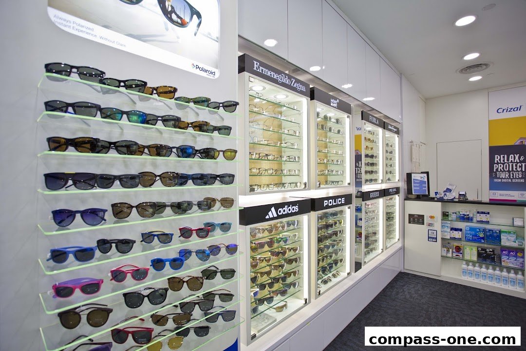 A well-lit optical shop displaying a wide selection of sunglasses and eyeglasses from various brands.