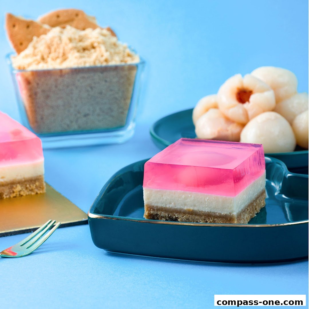 A close-up of layered jelly desserts with lychees and biscuit crumbs in the background.