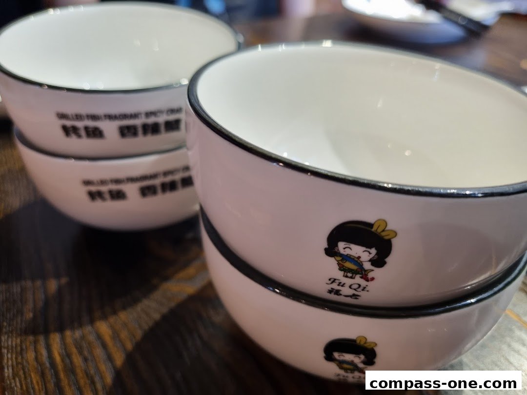 Close-up of stacked white bowls with black rims and cute cartoon characters.