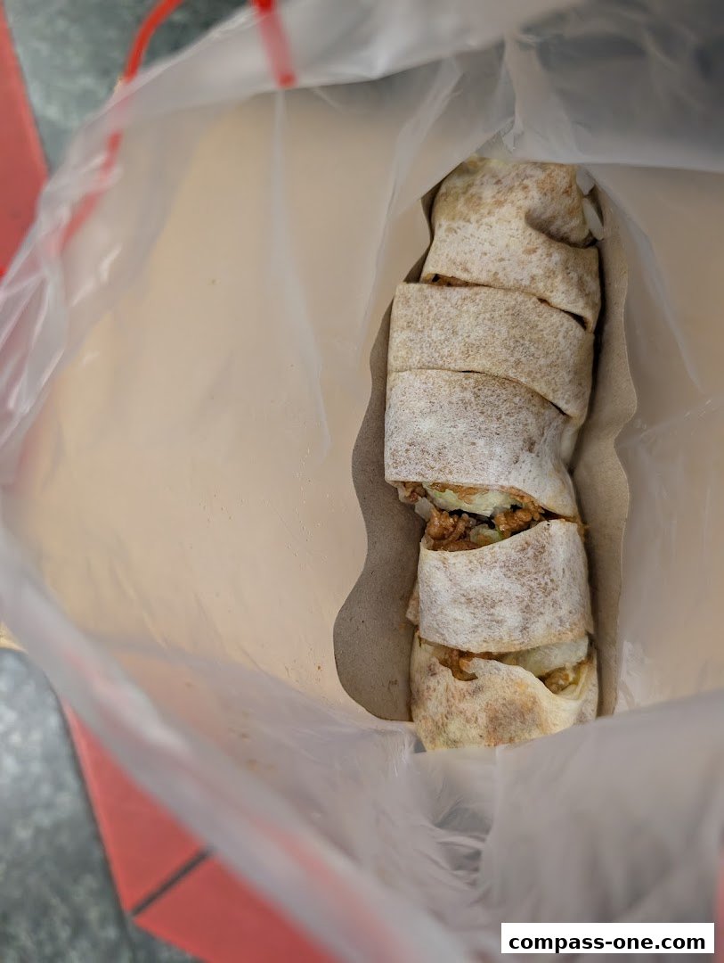 A close-up shot of a sliced popiah in a plastic bag.