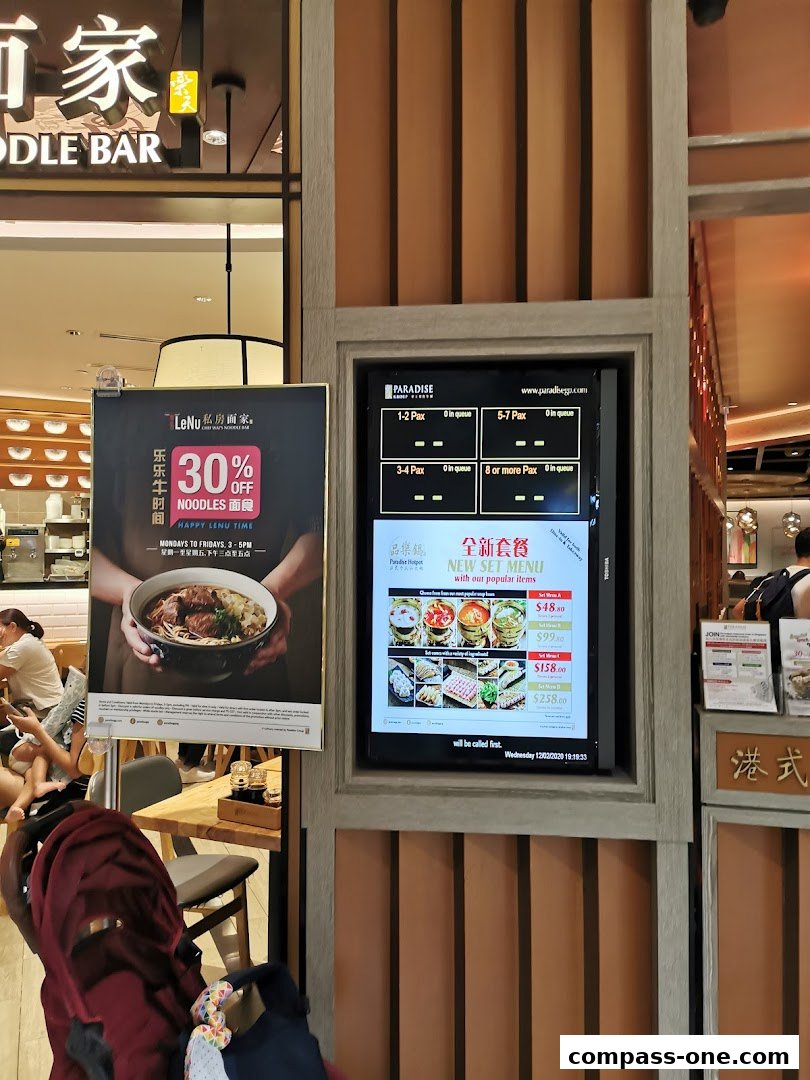 A digital menu board displays queue information and new set menus with prices at LeNu Chefs Wai Noodle Bar.