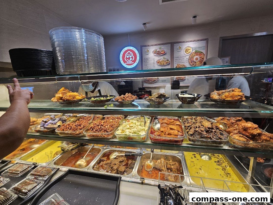 A display of various dishes in a food establishment, with stacked plates and a person pointing.