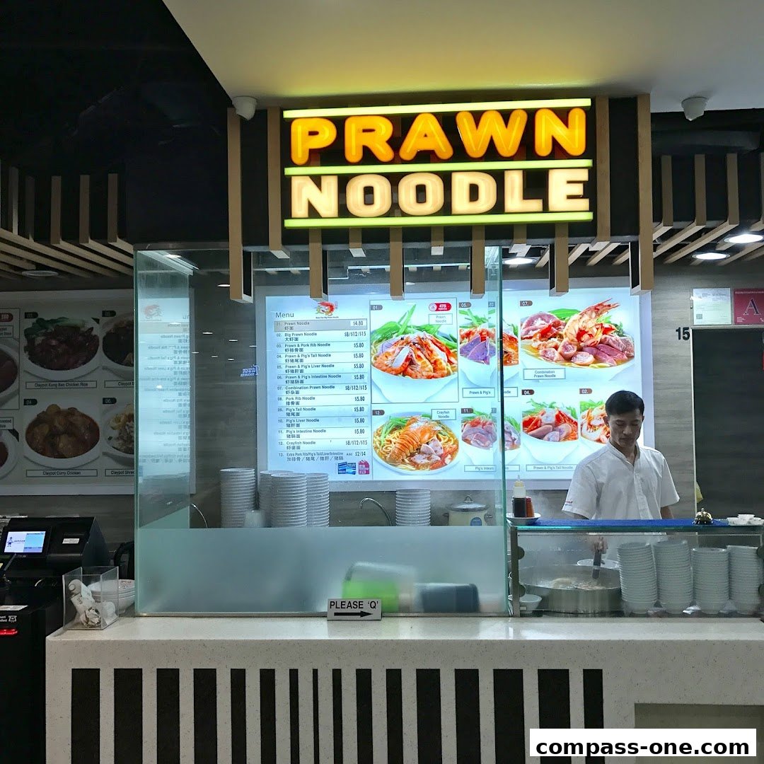 A food stall counter displaying a menu for prawn noodles with various options and prices.