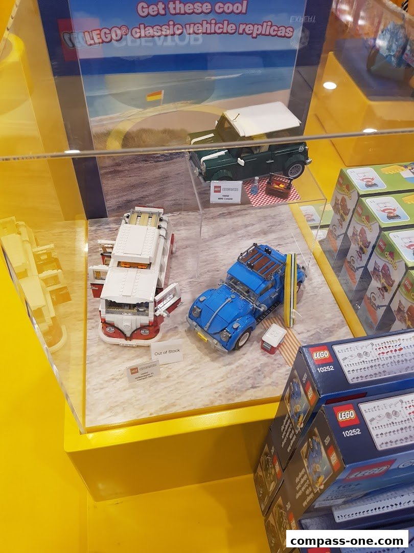 Display of LEGO classic vehicle replicas, including a green Mini Cooper and a blue Volkswagen.