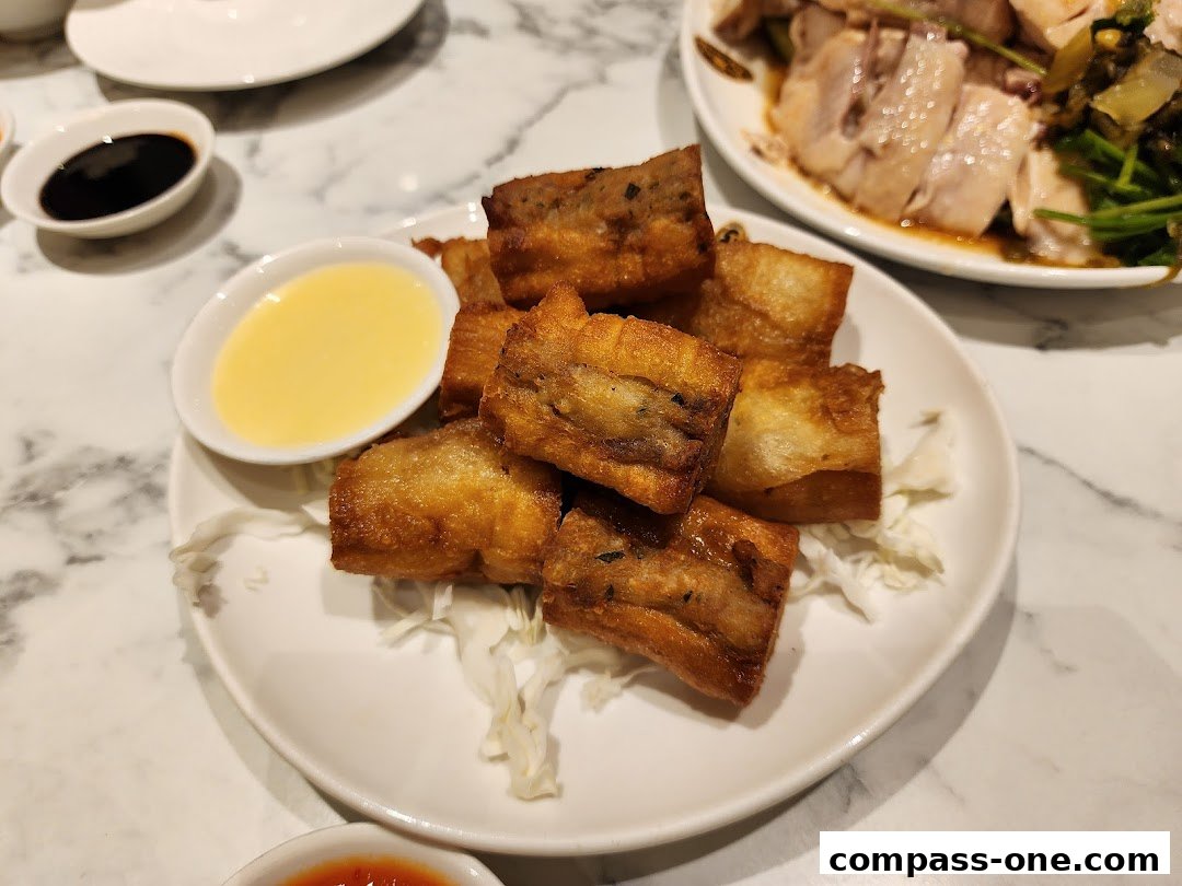 A plate of golden-brown fried food with dipping sauces and a dish of sliced meat and vegetables.