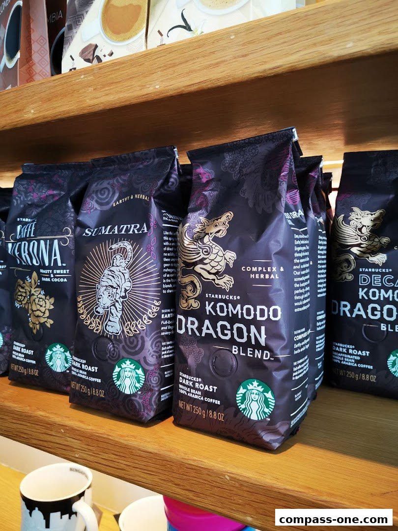 Bags of Starbucks coffee beans are displayed on a wooden shelf, featuring various blends like Sumatra and Komodo Dragon.