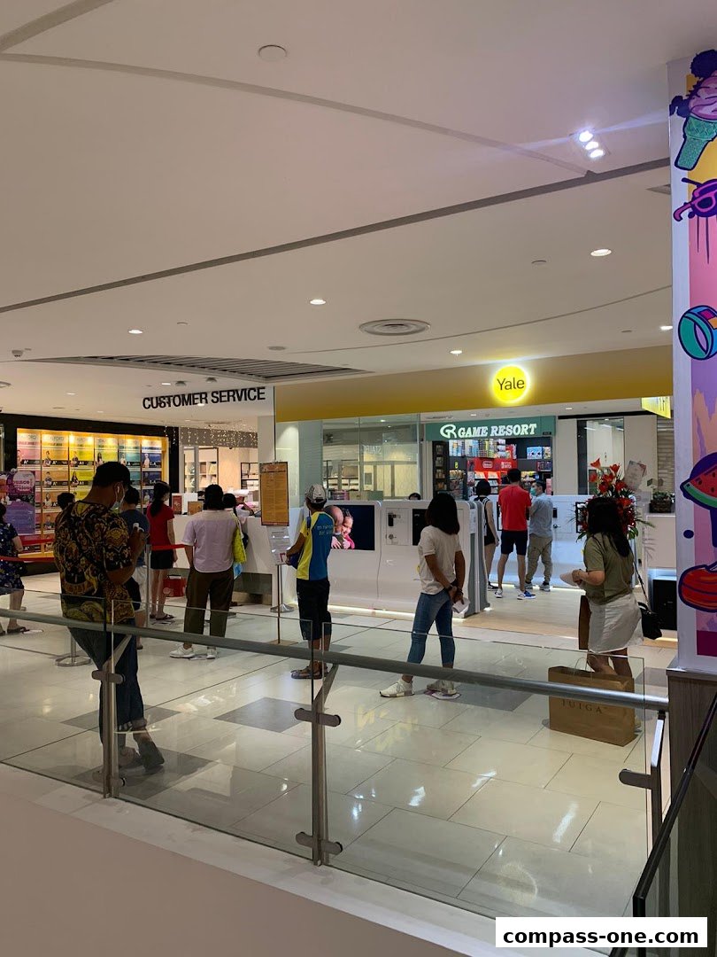 People queuing at the Yale Smart Shop and Customer Service counter in a mall.