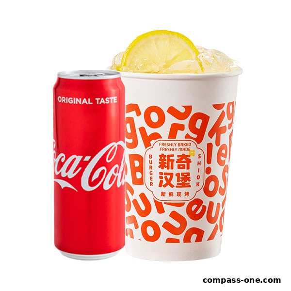 A can of Coca-Cola next to a cup of iced beverage with lemon from Shiok Burger.