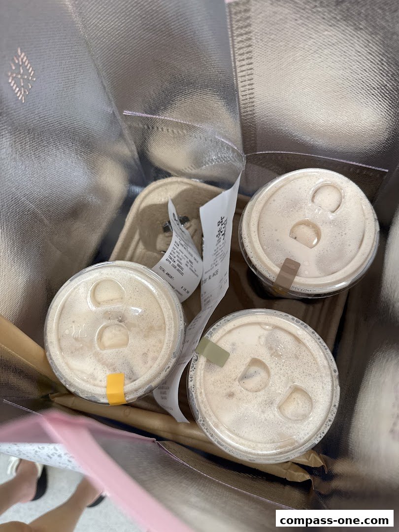 Three bubble tea drinks in a reusable shopping bag with receipts.
