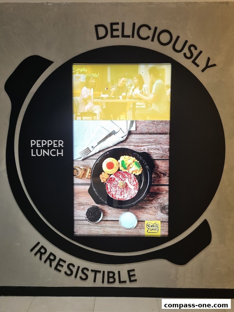 A Pepper Lunch advertisement featuring a sizzling steak dish and happy diners.