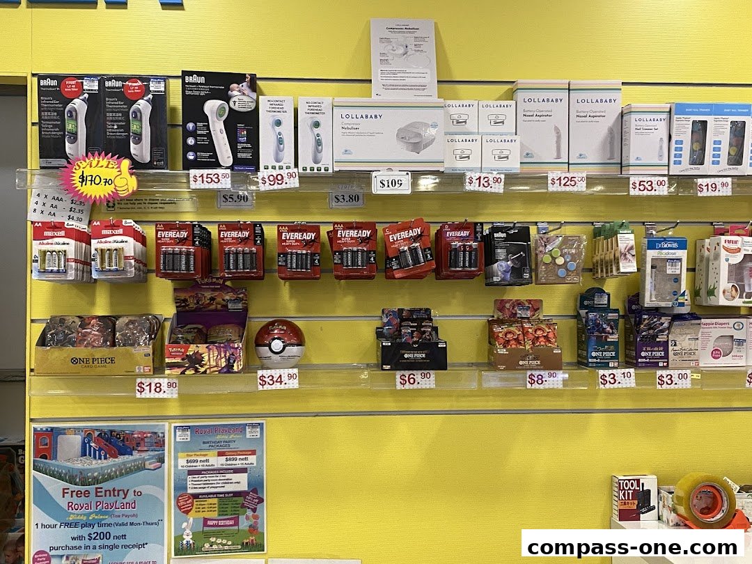 A retail display featuring thermometers, batteries, children's toys, and baby products.