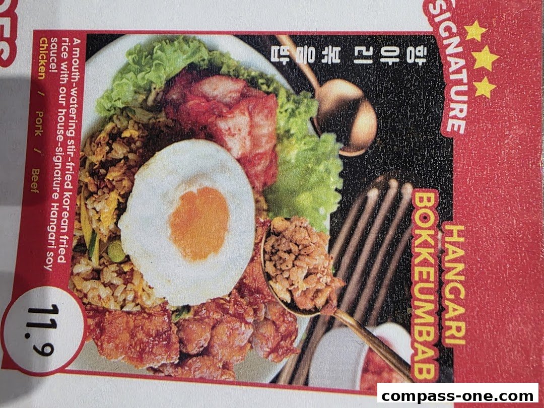 A close-up of a Korean stir-fried rice dish with a fried egg and meat.