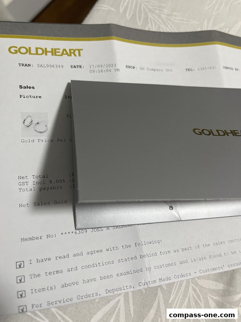 A Goldheart sales receipt and jewelry box are displayed on a patterned surface.