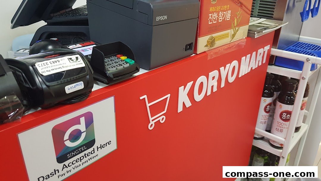 The Koryo Mart counter displays payment terminals, an Epson printer, and various products.
