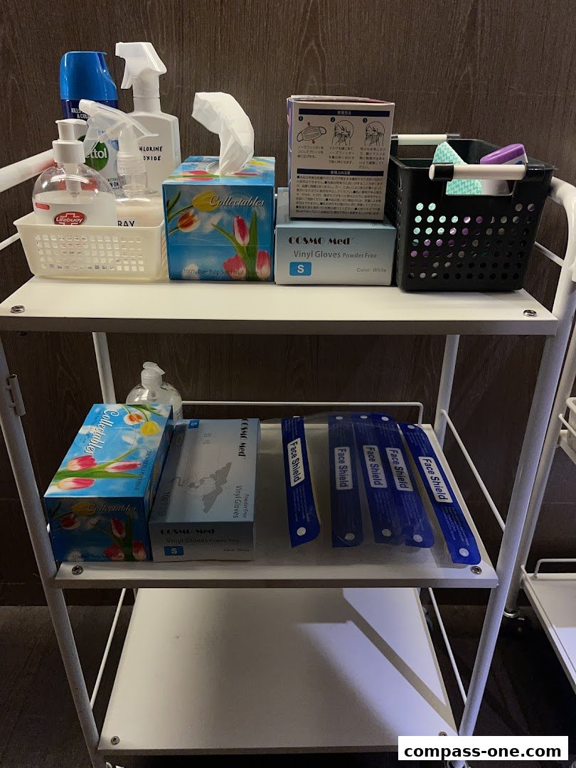 A trolley stocked with hygiene and personal protective equipment, including sanitizers, gloves, and face shields.