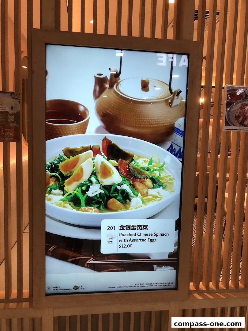 A digital menu board displays a dish of poached Chinese spinach with assorted eggs.