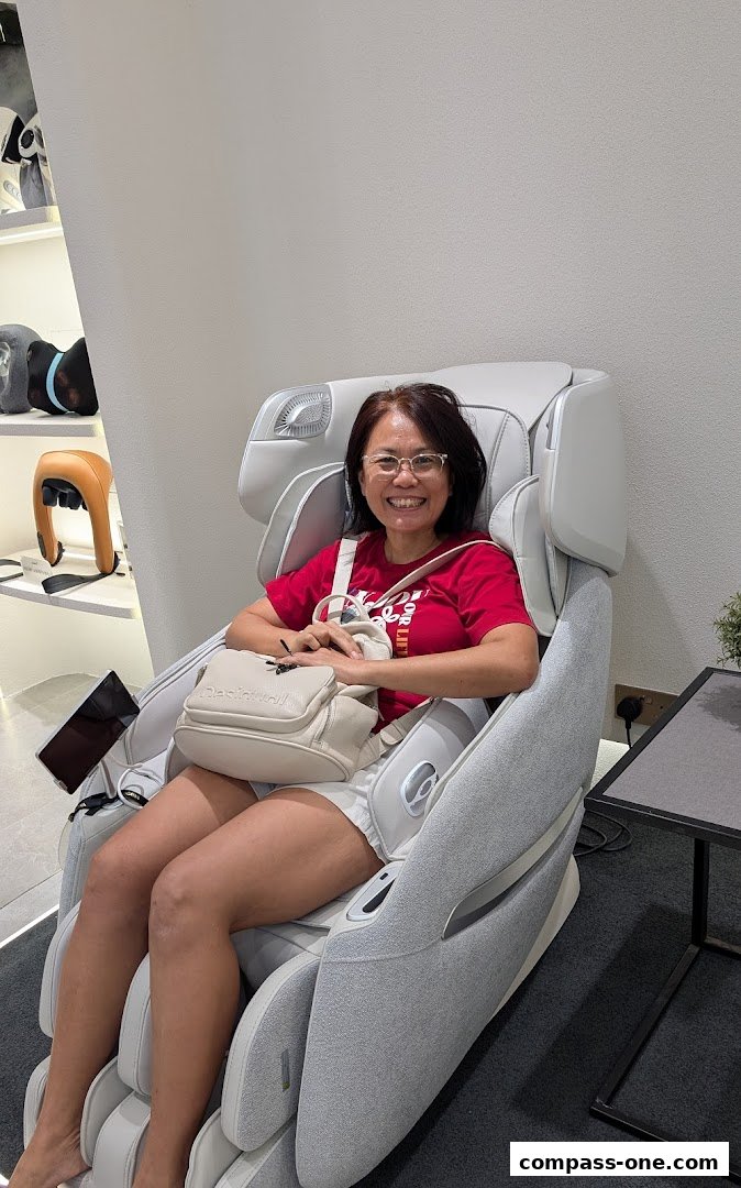 A woman smiles while sitting in a modern massage chair at OGAWA Compass One.