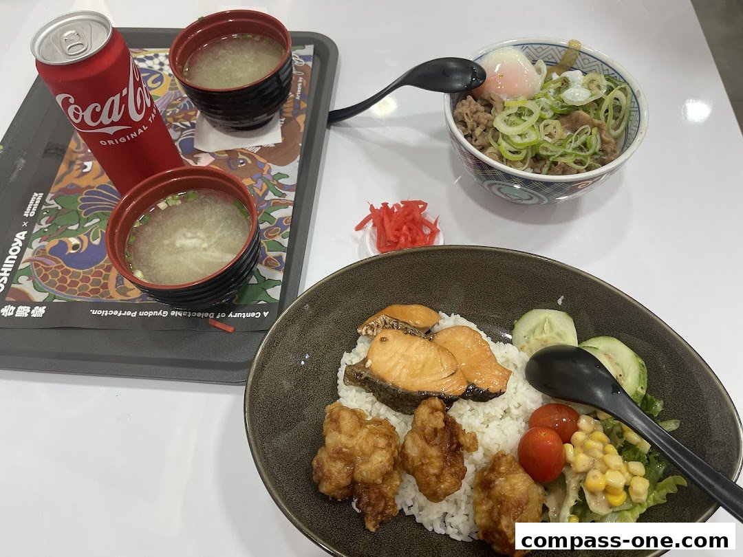 A tray with a Coca-Cola can, two bowls of miso soup, and two Japanese meals.