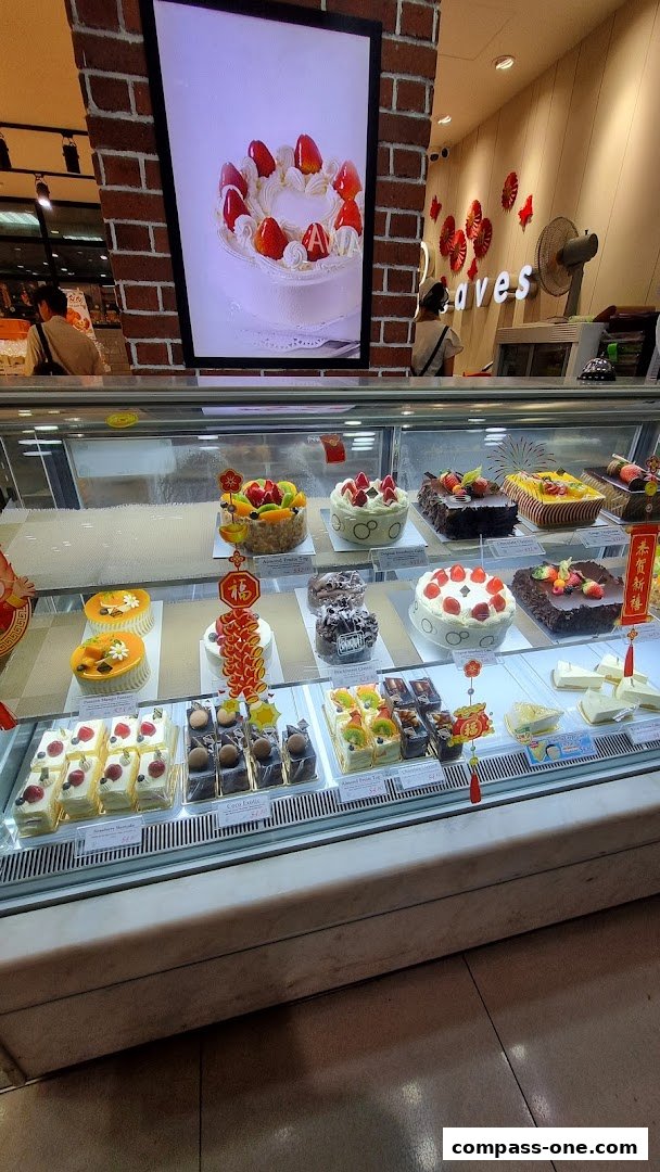 A display case filled with various cakes and pastries at the Four Leaves bakery.