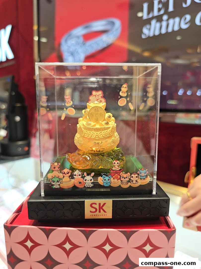 A golden prosperity treasure pot with cartoon zodiac animals displayed in a clear case.
