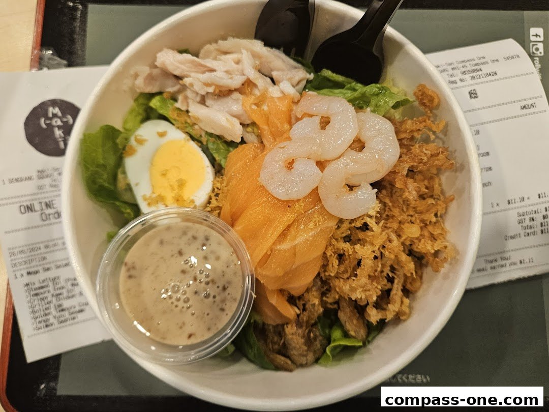A close-up of a salad bowl with salmon, chicken, egg, and shrimp, with a receipt in the background.