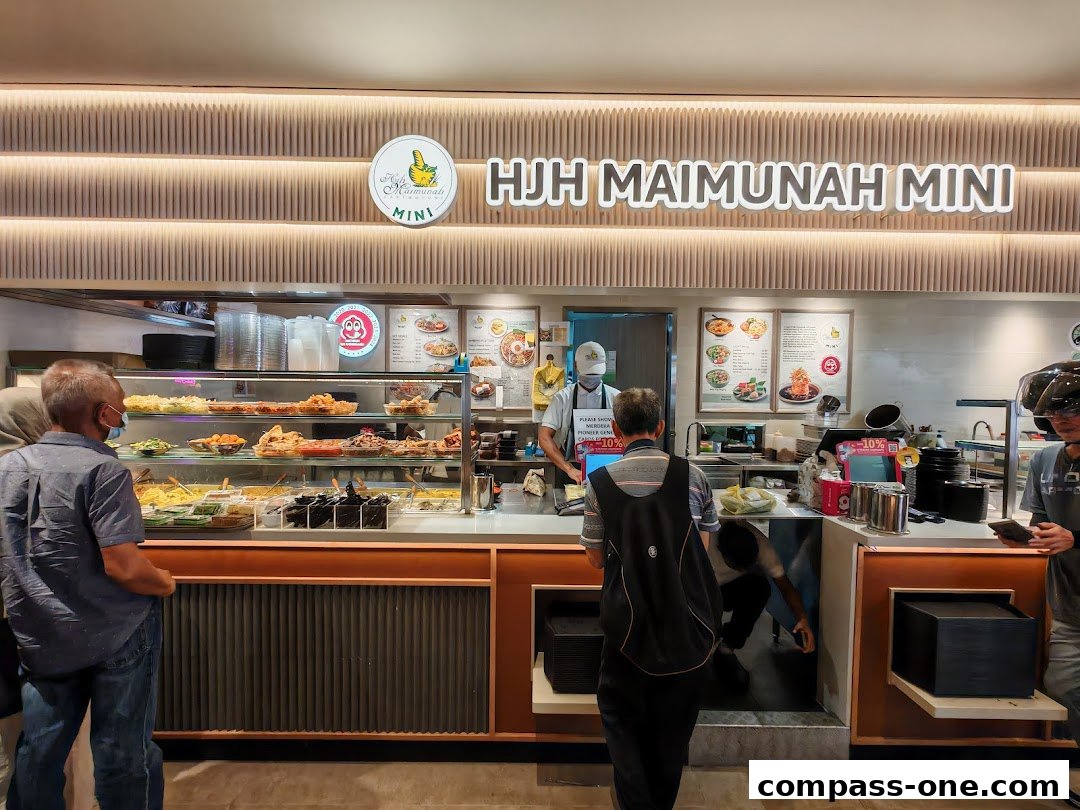 Customers queue at a food stall with a display of various dishes and a menu board.