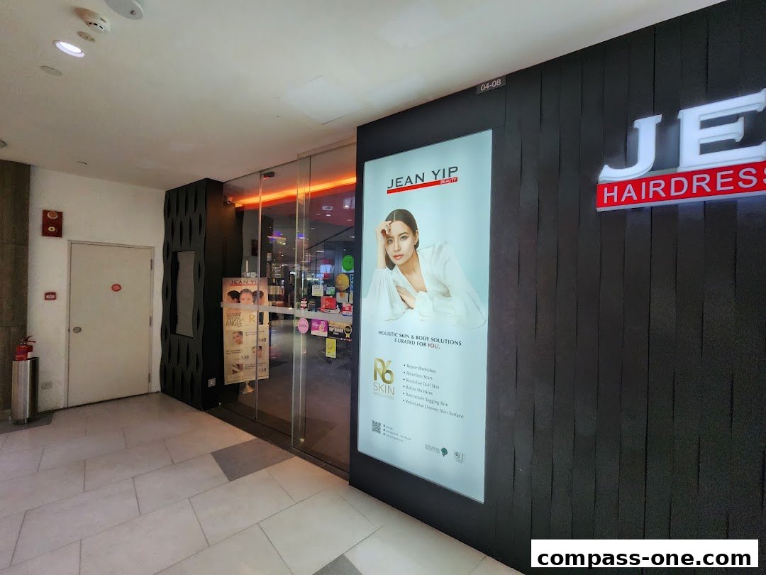 The exterior of Jean Yip Hairdressing salon with a large illuminated advertisement.