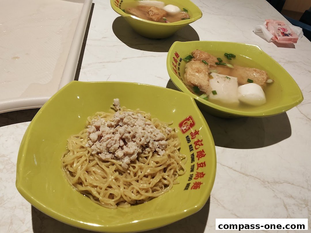 Two bowls of Yong Tow Foo Mee, one with noodles and minced meat, the other with soup and ingredients.