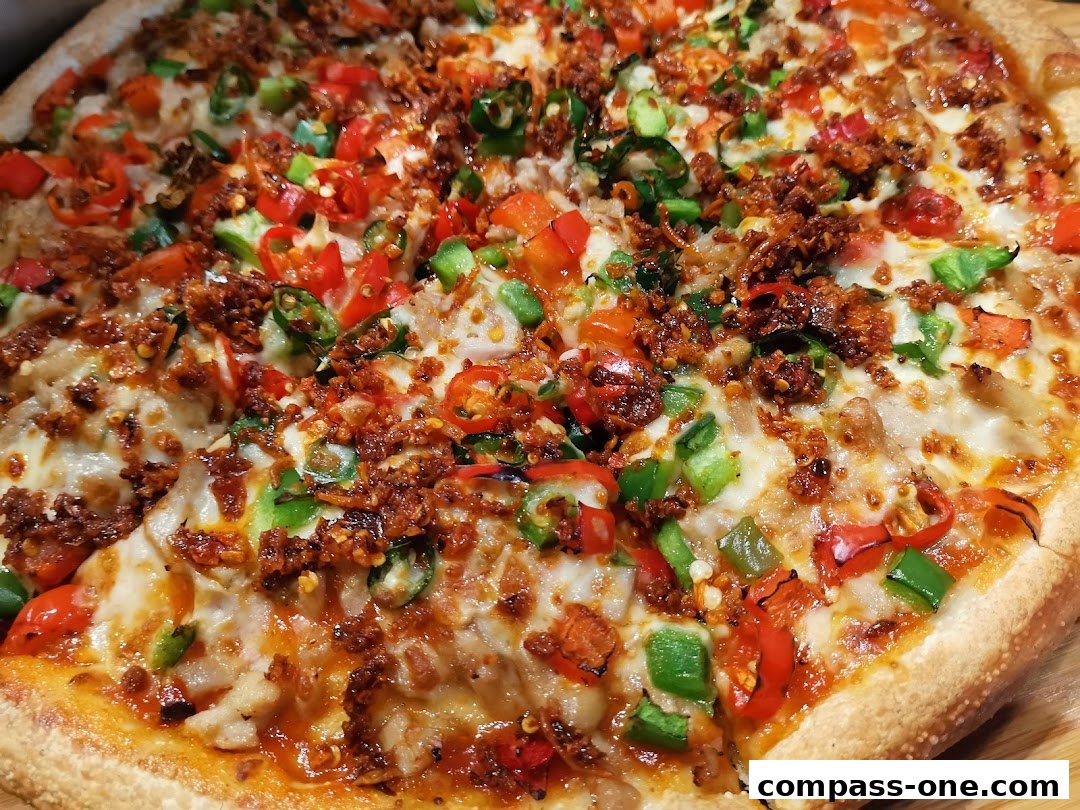 A close-up shot of a delicious pizza topped with peppers, chili, and meat.