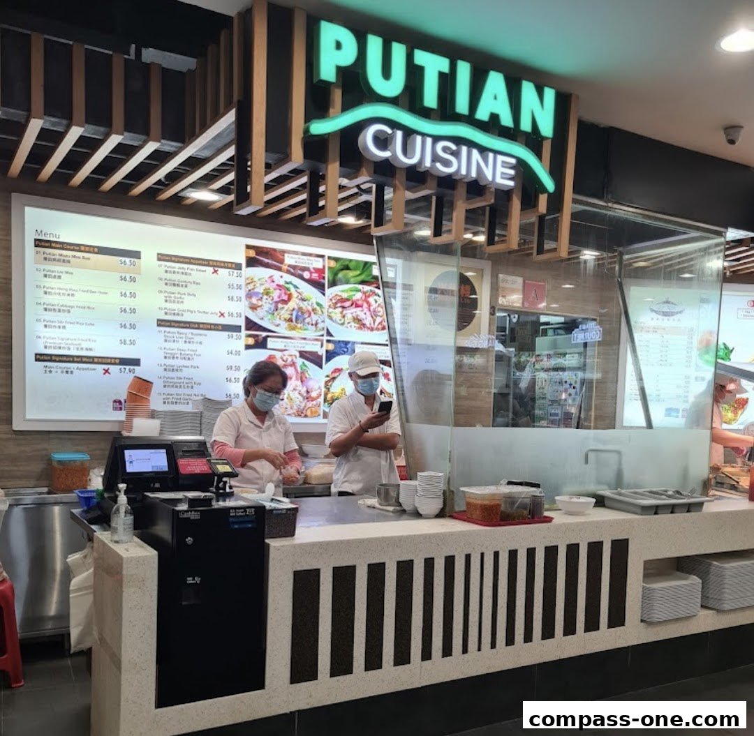A food stall counter with a menu board displaying various dishes and prices.