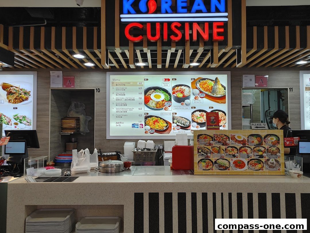 A counter display for King Dae Bak Korean Cuisine with a menu board and food images.