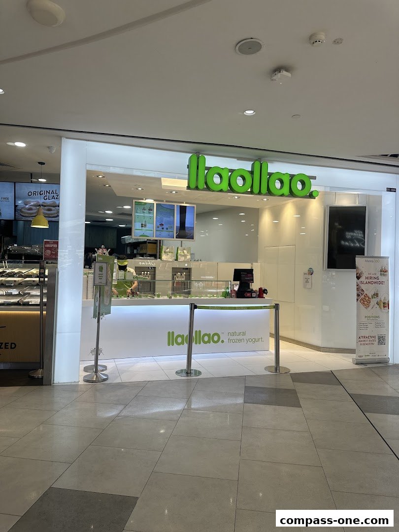 The exterior of a llaollao frozen yogurt shop with its signature green logo and clean white counter.