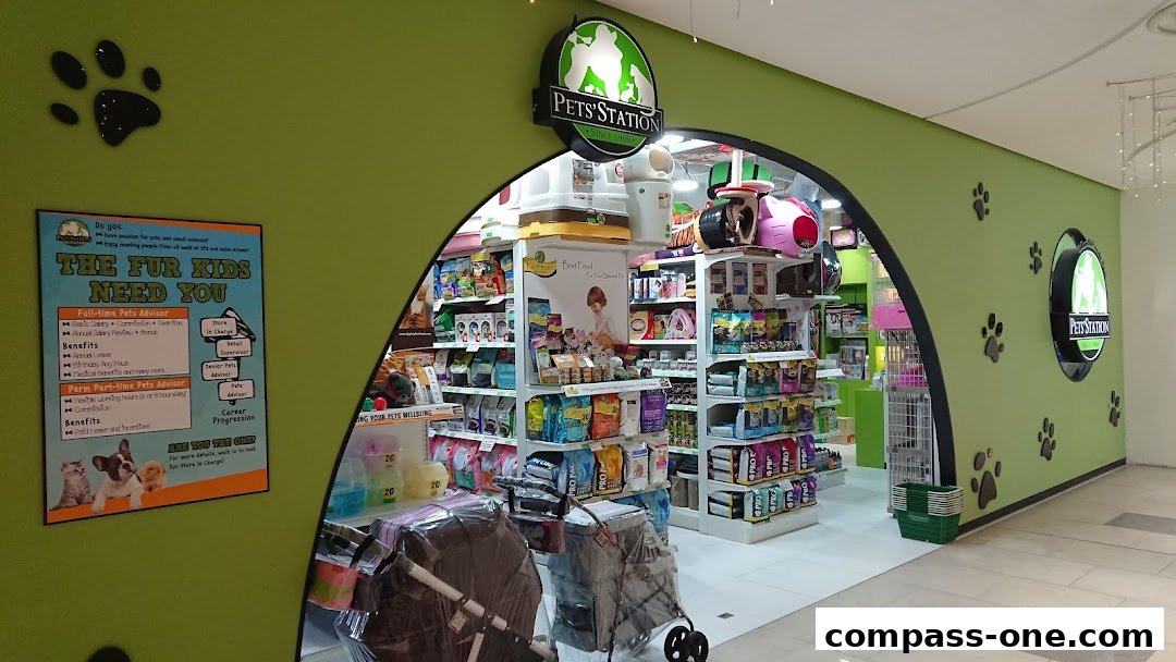 The entrance to a brightly lit pet store with shelves stocked with pet food and supplies.