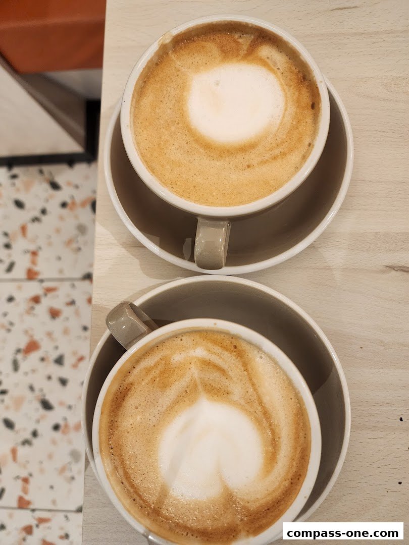 Two cups of coffee with latte art on a wooden table.