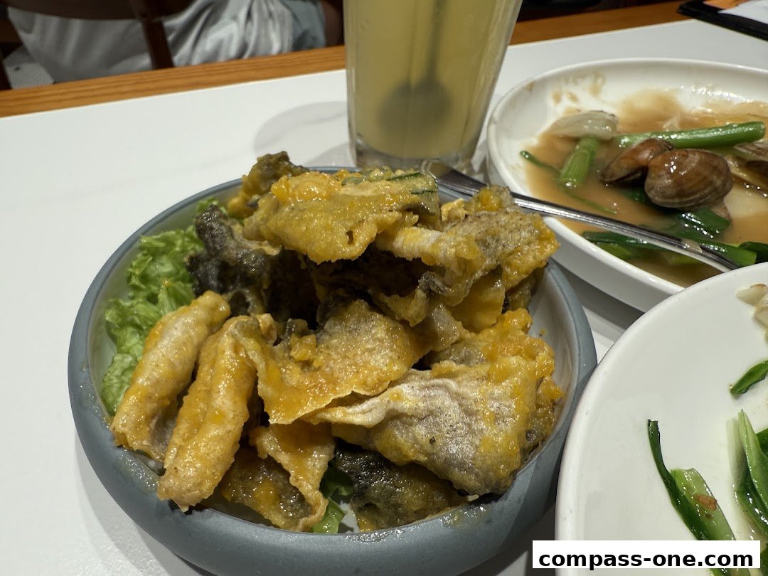 A close-up of crispy fried fish skin served with lettuce and other dishes.