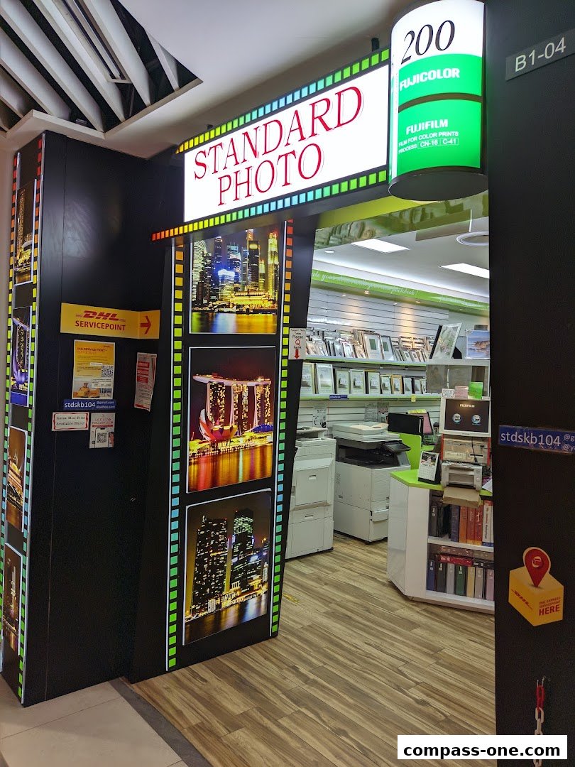 The entrance of Standard Photo, a shop with a DHL service point and photo displays.