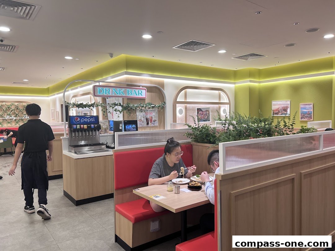 Diners enjoy meals at booths in a brightly lit restaurant with a visible drink bar.