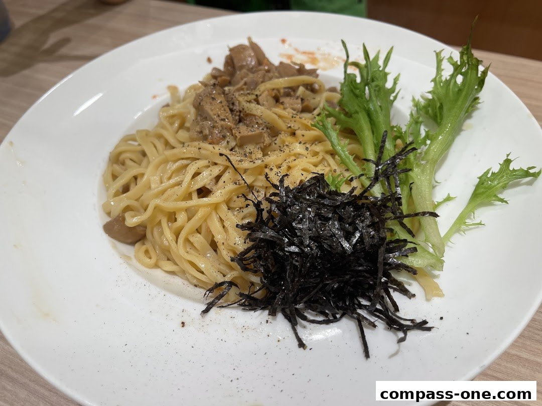 A plate of creamy pasta with mushrooms, seaweed, and fresh greens.