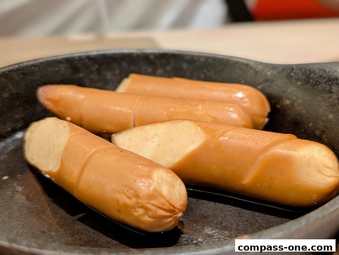 Close-up of juicy, grilled sausages served in a dark pan.
