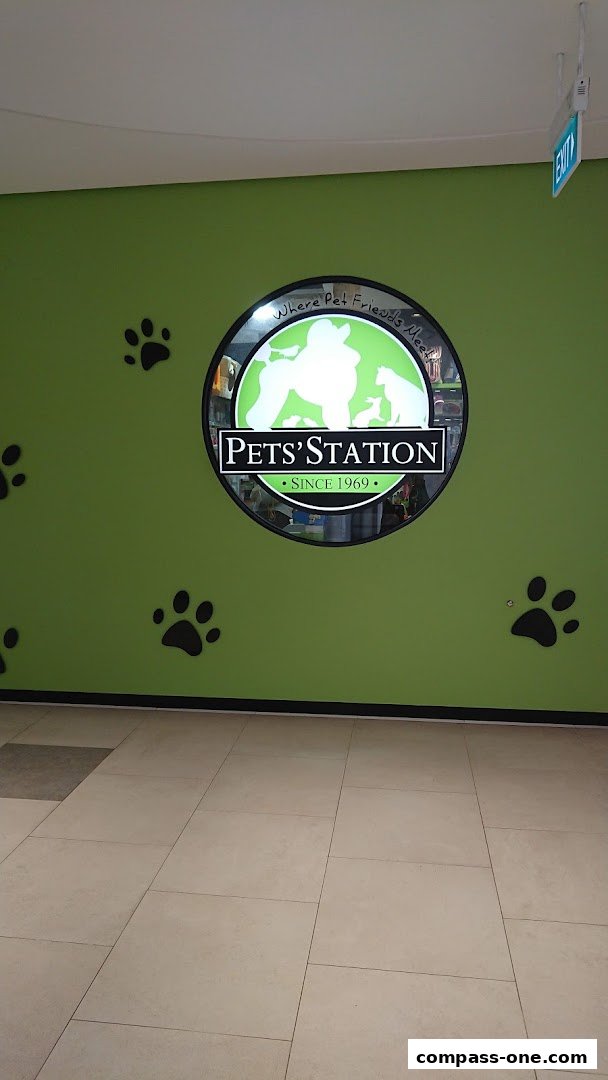 The Pets' Station logo is displayed on a bright green wall with paw prints.