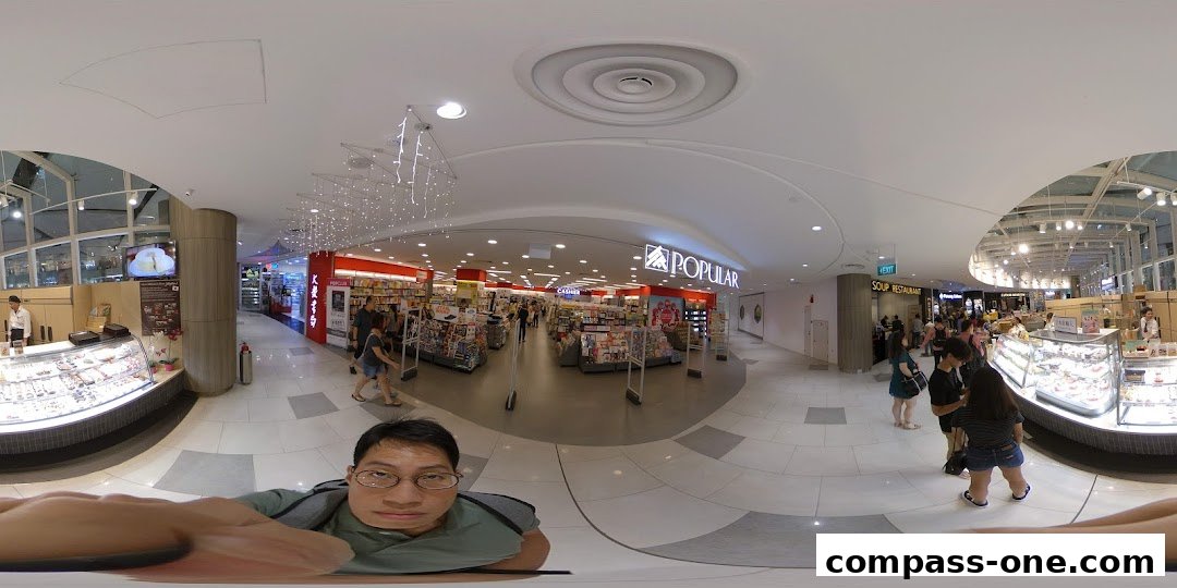 A wide-angle view of the interior of a POPULAR bookstore with shelves of books and customers browsing.