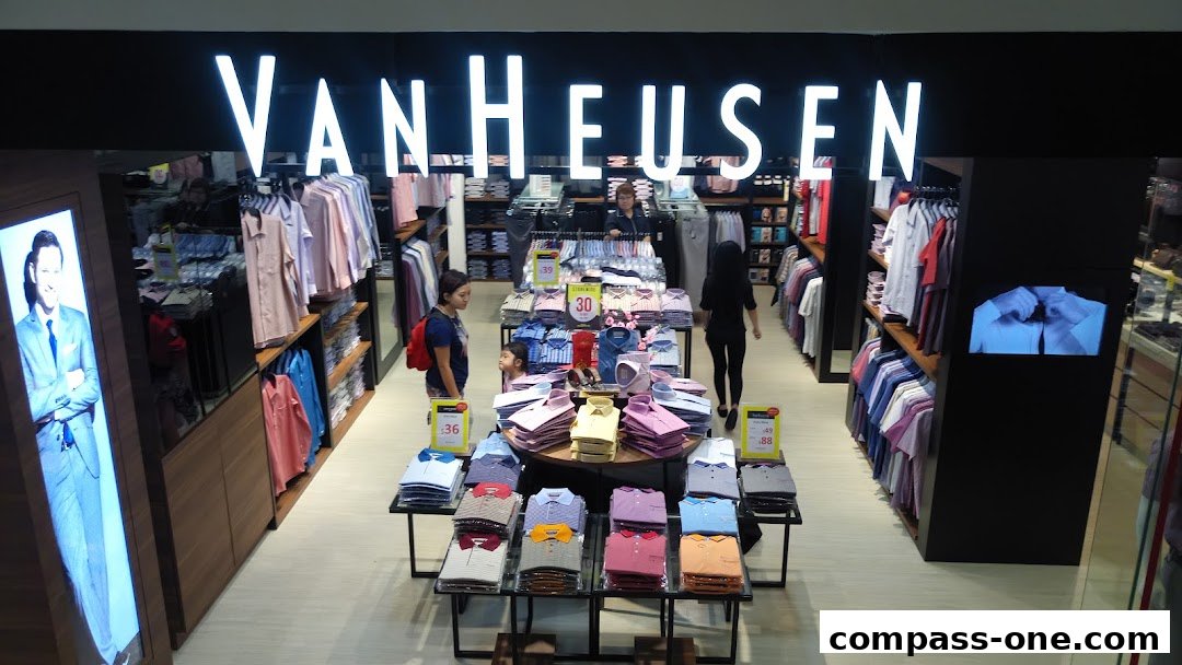 Interior view of a Van Heusen store showcasing neatly folded shirts and clothing racks.