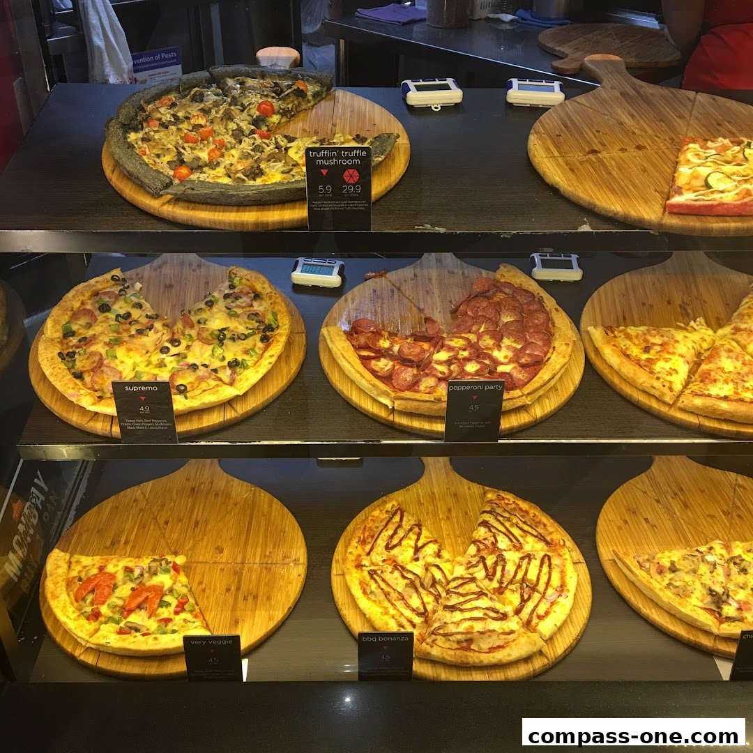 A display of various pizzas with labels and prices, showcasing different flavors.
