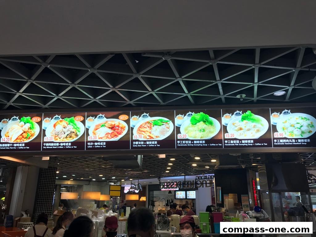 A brightly lit menu board displaying various noodle and soup dishes with prices.